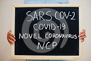 Sars Cov-2 Covid-19 novel NCP. Coronavirus concept. Boy hold inscription on the board