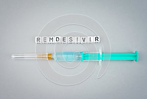 Alphabet dices with the word Remdesivir and syringe a possible treatment for Corona Virus photo