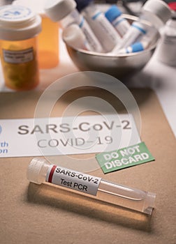 SarsCov2 coronavirus pcr vial together with a dossier folder indicating not to be discarded