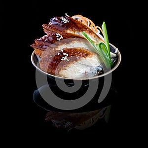 Sashimi with eel in a black plate. On a black background with re photo