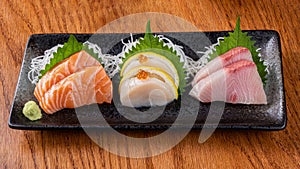 sashimi set, sushiset, salmon tona and yellow tail on the plate with wasabi on the table