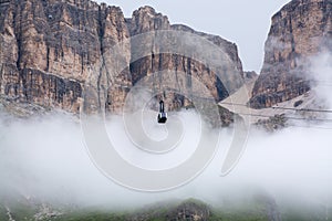 Sass Pordoi massif hidden in clouds with cable car leading on to