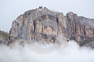 Sass Pordoi massif hidden in clouds with cable car leading on to