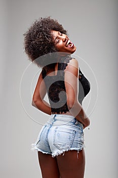 Sassy provocative sexy young Black woman in skimpy shorts