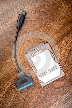 Sata cable next to hdd 2.5 hard drive disk on wooden table closeup view