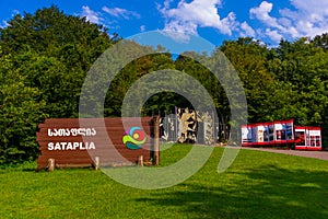 SATAPLIA, KUTAISI, GEORGIA: A sign and a fence with the image of dinosaurs in the Georgian Sataplia Nature Reserve.