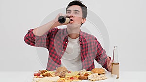 Sated Caucasian Man Enjoying Beer at Table on White Background