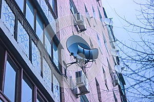 A satelite dish on a brick wall.