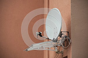 Satellite antena on orange home facade