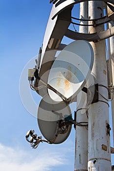 Satellite antenna on the pillar with blue sky