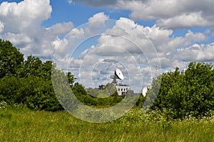 Satellite communication antenna in a field against a blue sky. Space Communication Center