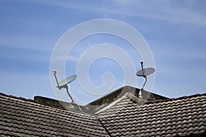 Satellite dish antenna installed on roof top over blue sky background