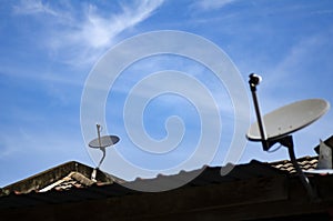 Satellite dish antenna installed on roof top over blue sky background