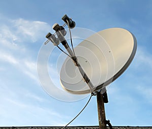 Satellite dish antenna over blue sky background