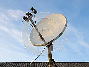 Satellite dish antenna over blue sky background