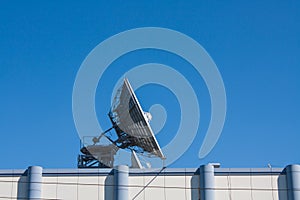 Satellite Dish Antenna on Top of Building, Blue Sky Background