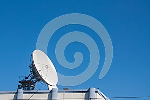 Satellite Dish Antenna on Top of Building, Blue Sky Background