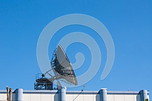 Satellite Dish Antenna on Top of Building, Blue Sky Background