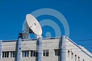 Satellite Dish Antenna on Top of Building, Blue Sky Background