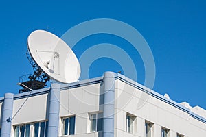 Satellite Dish Antenna on Top of Building, Blue Sky Background