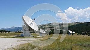 Satellite Dish Array in Open Landscape Under Clear Blue Sky