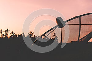 Satellite dish with colorful sky at sunset