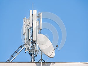 Satellite dish and GSM Cellular service telecommunication antenna on a building in the city of Bucharest., Romania