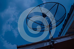 Satellite dish on house roof at night time