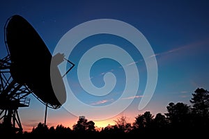 satellite dish silhouette against twilight sky