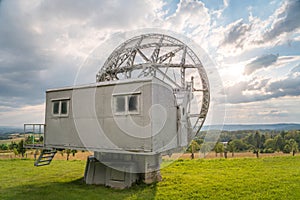 Satellite dish in a summer landscape, radiotelescope for deep space research. Ondrejov observatory, Czech republic.