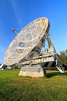 Satellite dish in a summer landscape, sky background.