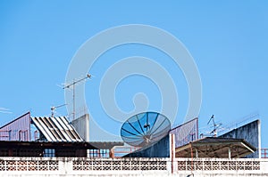 Satellite dish and television antenna on the old building with the blue sky background