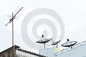 Satellite dish and television antenna on the old building with the blue sky background