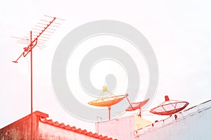 Satellite dish and television antenna on the old building with the blue sky background