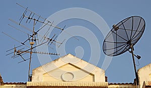 Satellite dish and television antenna on roof