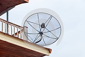 Satellite dish television sky overcast communication technology network on roof of house.