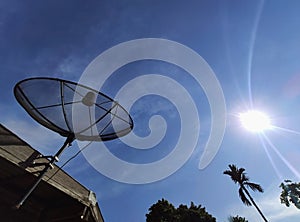 Satellite dishes communication technology network with sun and Blue sky surf in background,Satellite dish In the countryside