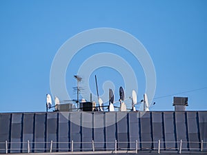 Satellite dishes on the roof of a building with place for text