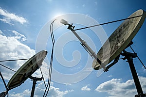 Satellite dishes with sky background.