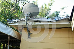 Satellite mounted-roof-home mounted on the roof of a home that is covered with a FEMA type tarp