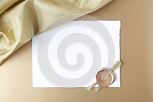 Satin on golden background with blank paper. Flat lay. Top view