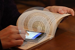 Satirical image of smartphone with social network in book