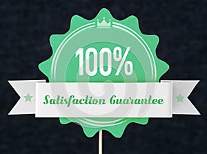 100% satisfaction guarantee badge cut from cardboard photo