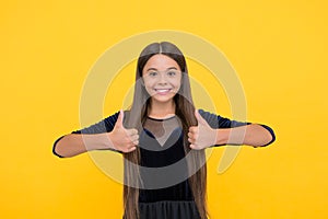 Satisfaction guaranteed. Happy child show thumbs ups yellow background. Satisfactory hand gesture. Satisfaction concept