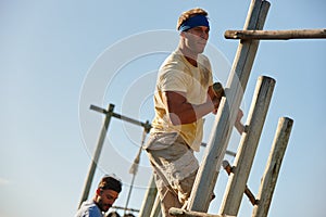 Satisfaction is overcoming the things you once thought you couldnt. men going through an obstacle course at bootcamp.