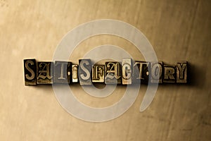 SATISFACTORY - close-up of grungy vintage typeset word on metal backdrop