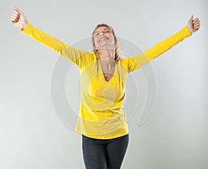 Satisfied 20s blond woman outstretching her arms for wellbeing
