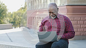 Satisfied African American client elderly man showing thumb up gesture complacent with service, recommends website