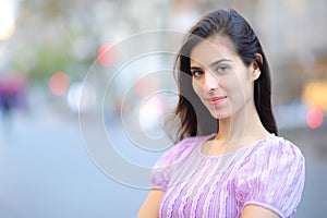 Satisfied beauty woman posing looking at you in the street