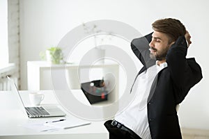 Satisfied businessman relaxing leaning back in chair